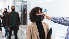 Female professional goes through temperature check before going to work in office