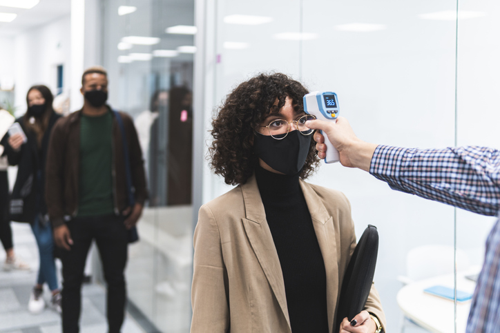 Female professional goes through temperature check before going to work in office