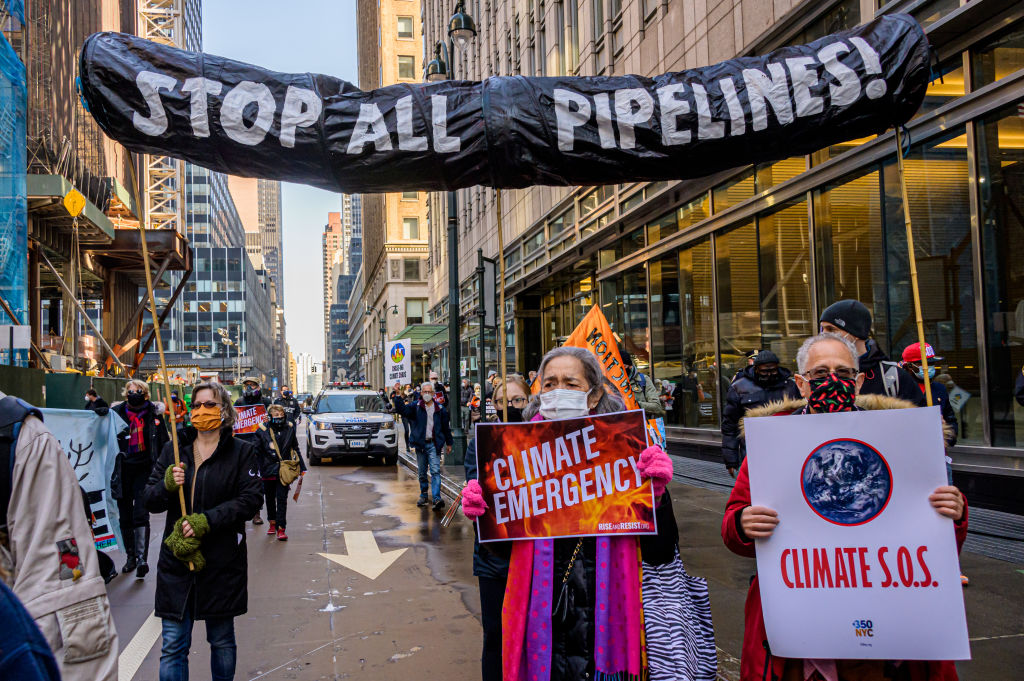 Participant seen holding a sign at the protest. Climate...