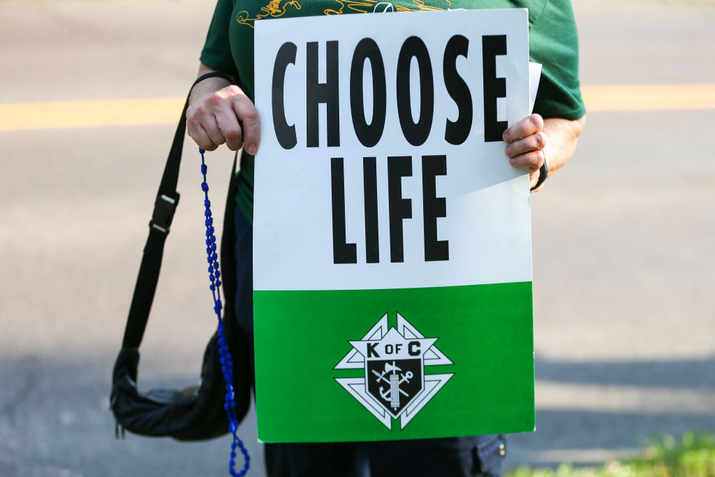 A demonstrator holds a placard reading "choose life" during...