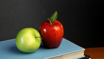 Red and green apple on stack of books