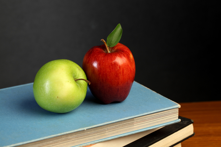Red and green apple on stack of books
