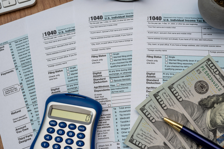 tax forms, calculator, pen dollar money on desk. View from above. Time for tax