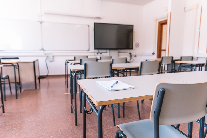 Notebook with a pen on a table in a classroom at a school
