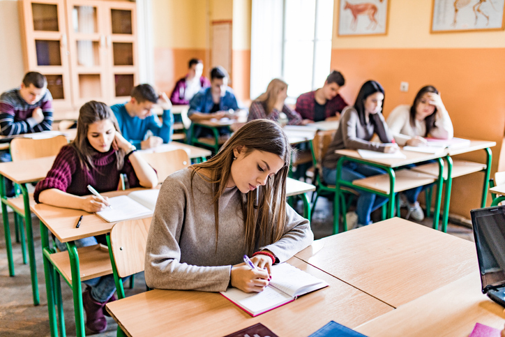 Group of high school students writing a test in the classroom.