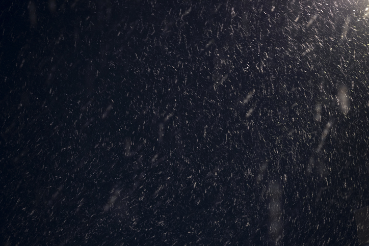 A streetlight illuminates the snowstorm at night