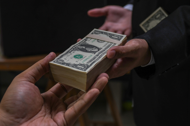 Businessmen secretly passing money - bribery and corruption concepts