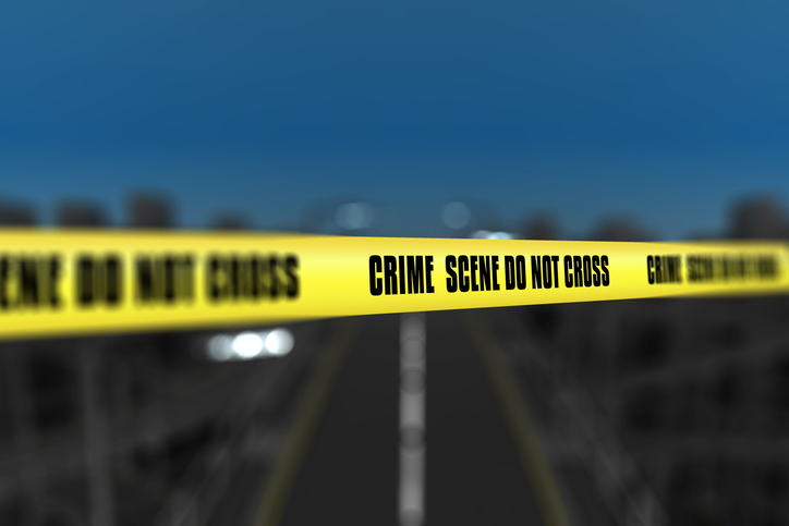 3D police line tape against defocussed city background