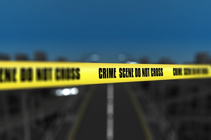 3D police line tape against defocussed city background