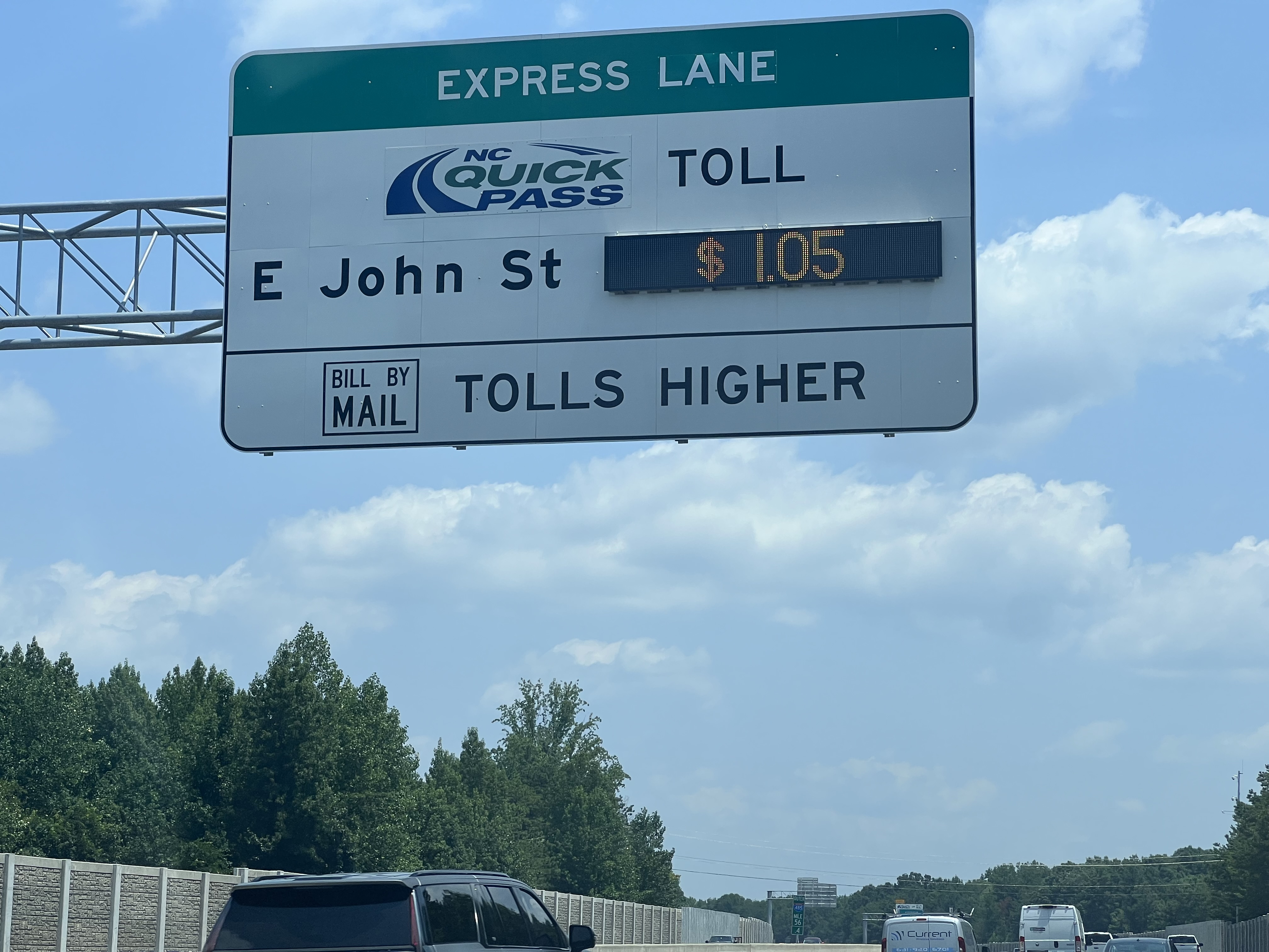 Express Lane toll sign showing $1.05 toll for E John St, with "Tolls Higher" text below and the NC Quick Pass logo.